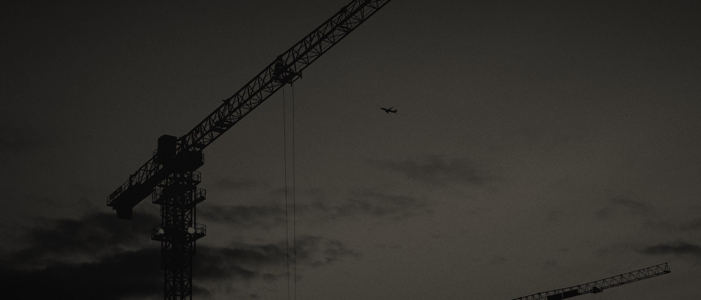 Tower crane silhouetted against a dusk sky